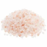 Coarse pink Himalayan salt crystals pile isolated on white background